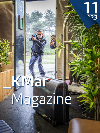 Kiosk-afbeelding van KMarMagazine. 2 marechaussees staan met getrokken wapen in een deuropening.