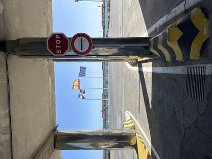 De controlepost met een stopbord, met op de achtergrond het water voor Ceuta en drie wapperende vlaggen.