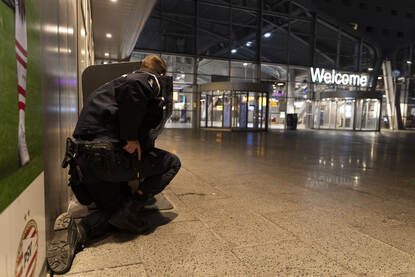 Marechaussee gehurkt bij de ingang  van Eindhoven Airport.