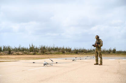 Operator met drone op landingsbaan.