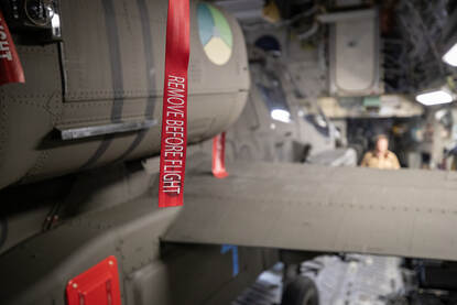 Closeup van een veiligheidstag met daarop de tekst ‘Remove before flight’ en verder wazige achtergrond.