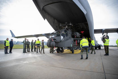 De neus van een Apache rolt uit het ruim van een C-17-transportvliegtuig.