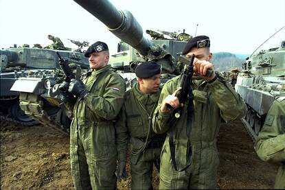 Drie cavaleristen in overall voor hun Leopard 2A4 gevechtstank.