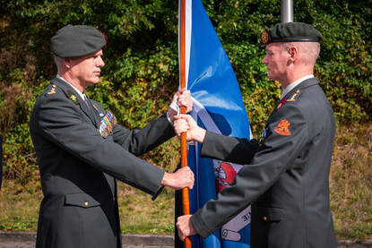 Kolonel Dave van Noort draagt de vlag van het KPU-bedrijf over aan de nieuwe commandant kolonel Jan Vonk.