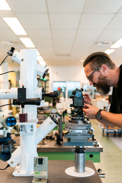 Testopstelling voor een landmeter op een tafel met daarachter meer opstellingen.