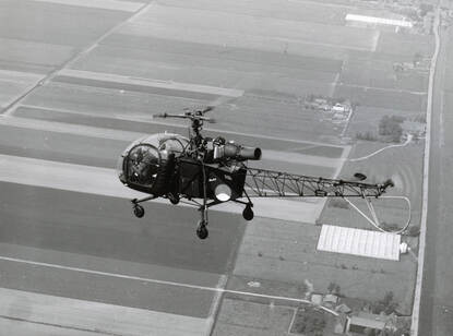 Alouette II boven Nederlands polderlandschap.