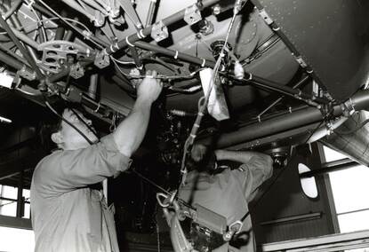 Twee monteurs plegen onderhoud aan de onderzijde van een Alouette.