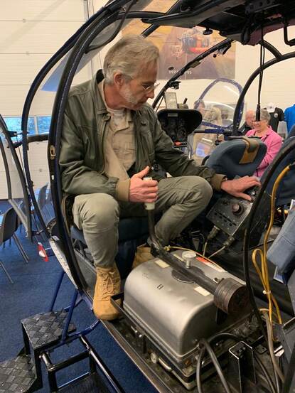 Arnoud Schoor in Alouette helikopter op stoeltje van fotograaf.