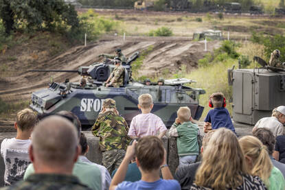 Een YPR-765 infanteriegevechtsvoertuig van de Koninklijke Landmacht rijdt door de arena van het NMM, omringd door publiek tijdens het Zomeroffensief.