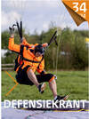 Een Nederlandse parachutist met oranje parachute landt op een kussen.